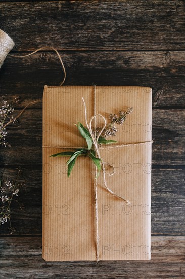 Present wrapped in brown paper with string and flowers
