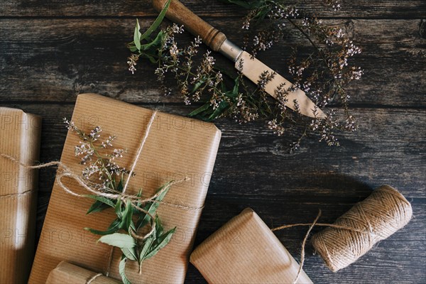 Presents wrapped in brown paper and string with flowers and knife