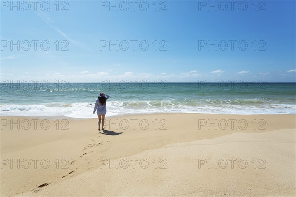 Woman walking on beach in Lisbon, Portugal