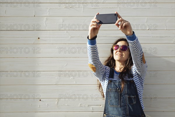 Woman wearing sunglasses taking selfie