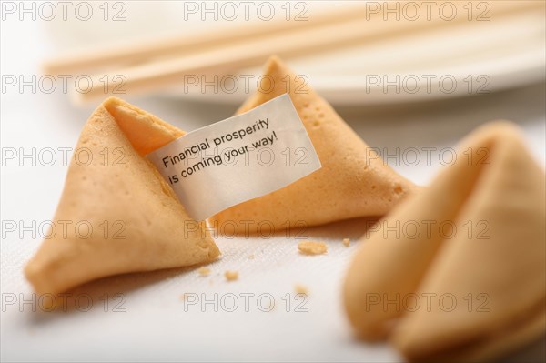 Fortune cookies by chopsticks on plate
