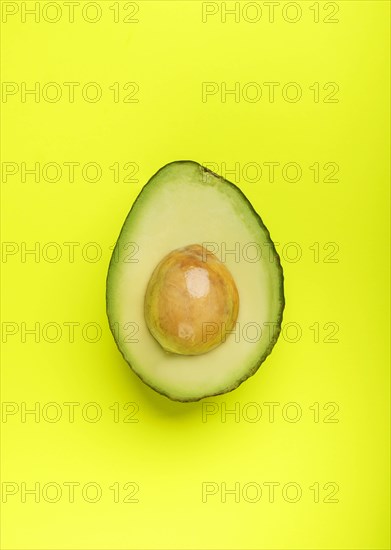 Halved avocado on green surface