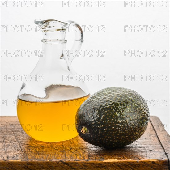 Avocado with pitcher of oil