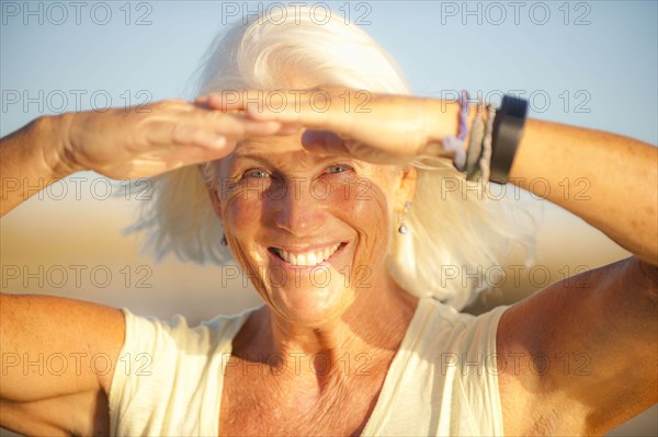 Portrait of smiling mature woman shielding her eyes