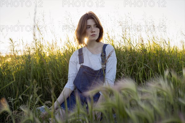Young woman sitting in wheat field