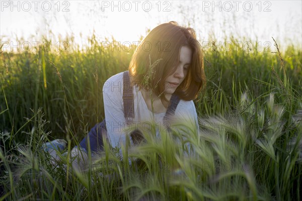 Young woman sitting in wheat field