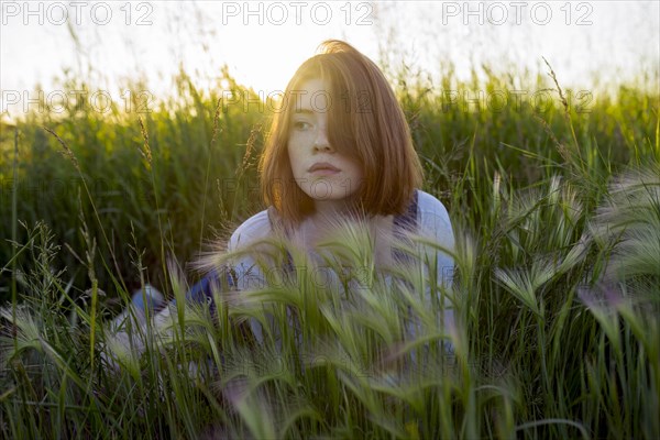 Young woman lying in wheat field