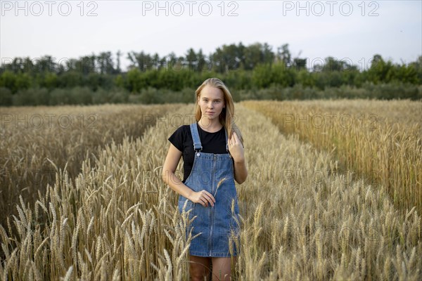 Young woman wearing overall dress in wheat field
