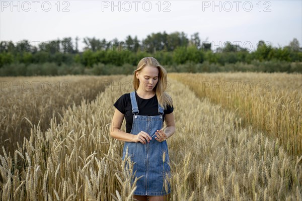 Young woman wearing overall dress in wheat field