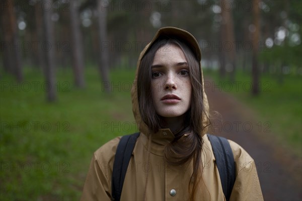 Portrait of young woman wearing brown raincoat