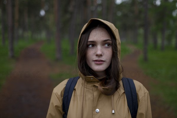 Portrait of young woman wearing brown raincoat