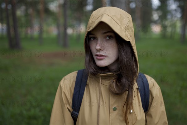 Portrait of young woman wearing brown raincoat