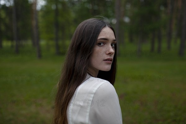 Young woman by forest