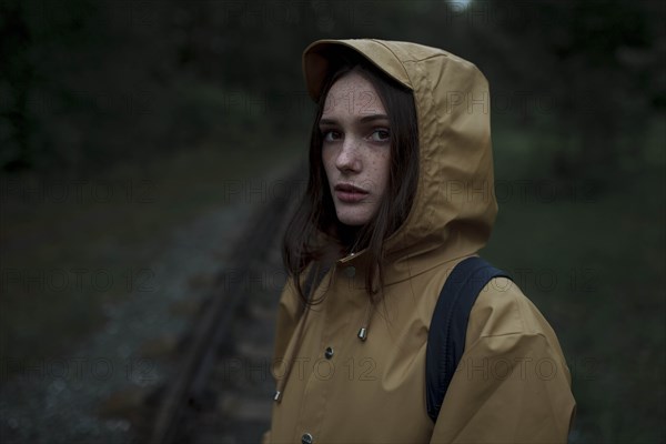 Young woman wearing brown raincoat