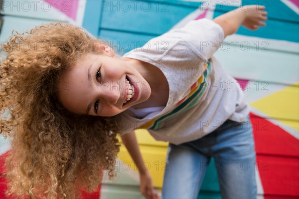 Girl in front of colorful wall