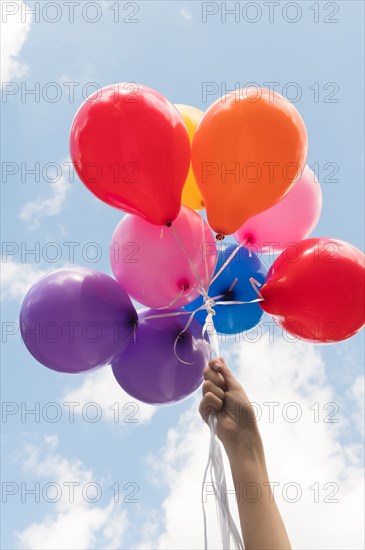 Girl's hand holding balloons