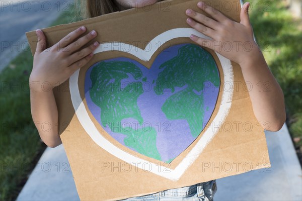 Young environmental activist holding sign