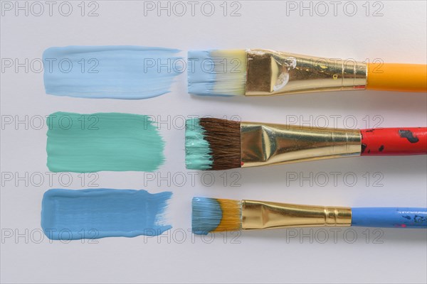 Paintbrushes and blue brushstrokes