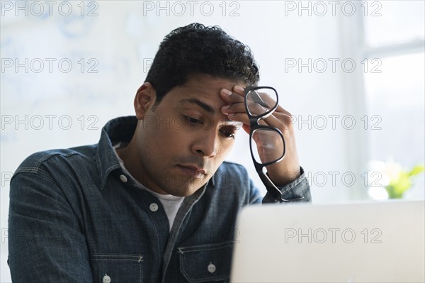 Stressed businessman working on laptop