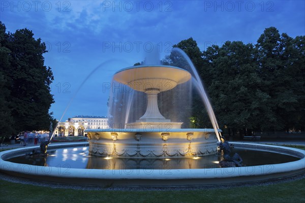 Fountain at night in City buildings at night in Warsaw, Masovia, Poland