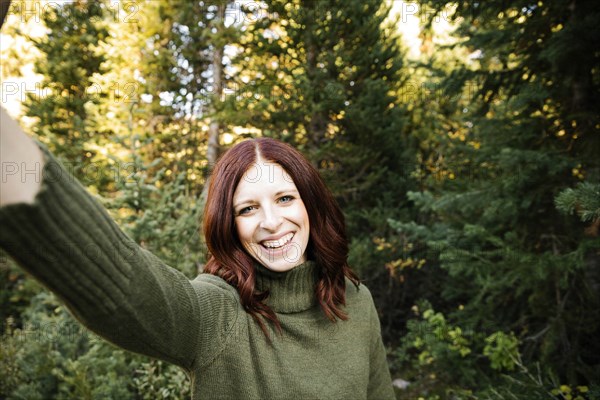 Woman taking selfie in forest