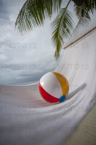 Beach ball on hammock under palm tree in Ari Atoll, Maldives, South Asia