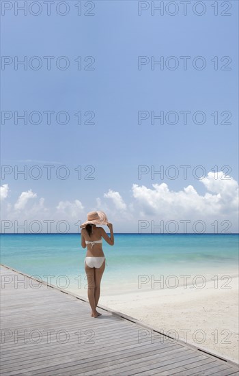 Woman wearing bikini by beach in South Male Atoll, Maldives, South Asia