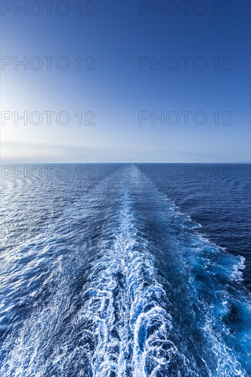 Wake in sea under clear sky