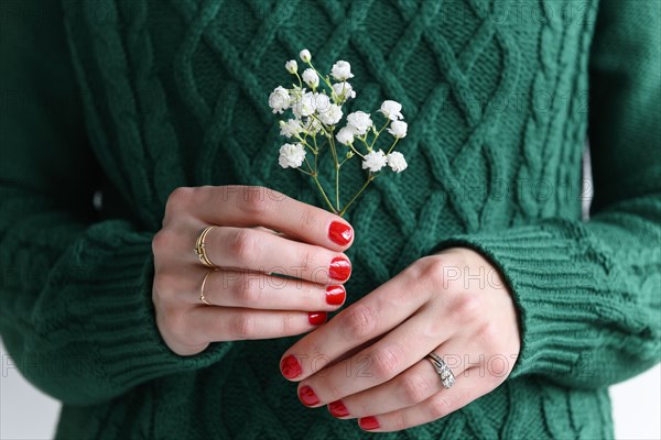 Woman wearing green holding white flowers