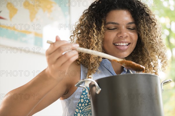 Smiling woman stirring pot