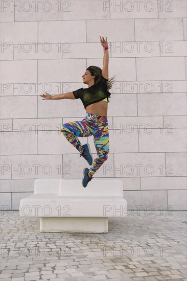 Woman jumping by wall