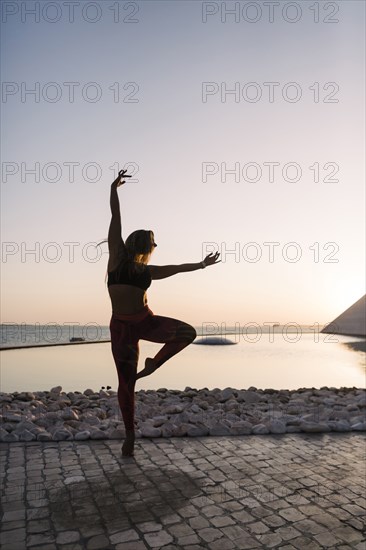 Silhouette of woman dancing at sunset