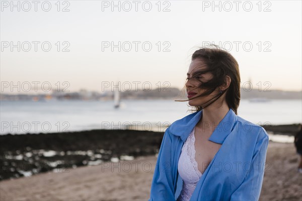 Woman wearing blue jacket by sea