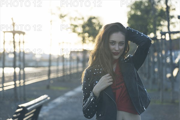 Woman wearing leather jacket on footpath in Lisbon, Portugal