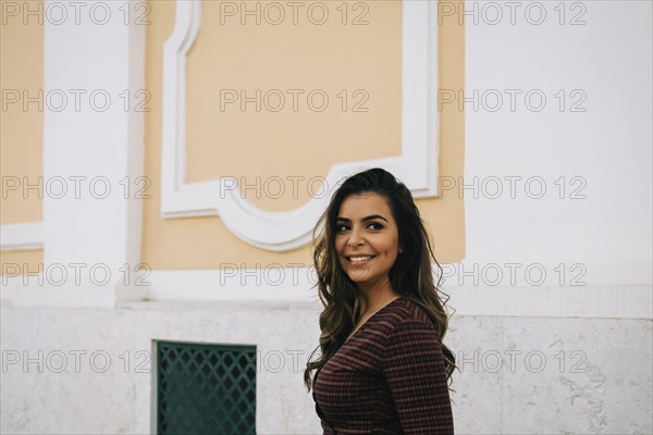 Smiling woman by wall