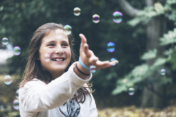 Smiling girl playing with bubbles