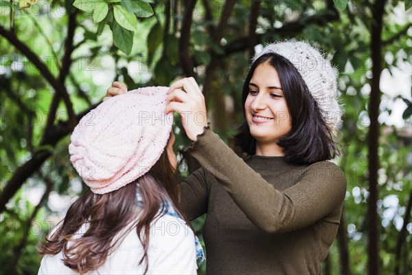 Girl adjusting sister's hat