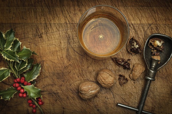 Mistletoe, drink in glass, walnuts and nut cracker