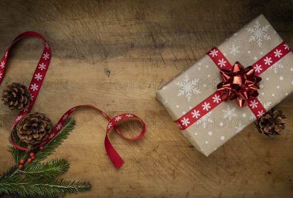 Christmas present, pine fronds, pinecones and ribbon