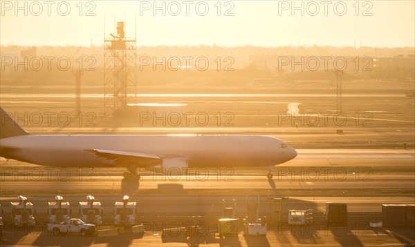 Airplane on runway at sunset