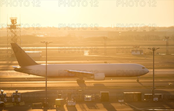 Airplane on runway at sunset