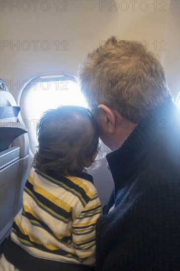 Man and child looking out airplane window
