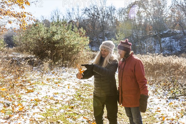 Women looking at autumn leaf