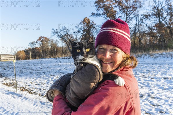 Woman holding cat in snow