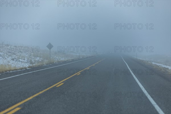 Road by snow in fog