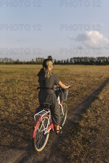 Woman riding bicycle in field