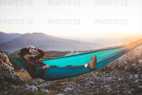 Man sleeping on hammock in mountain range