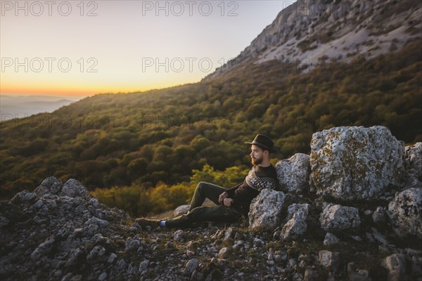 Man lying on rock by mountain