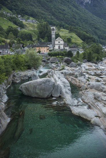 Bell tower by river in Ticino, Switzerland
