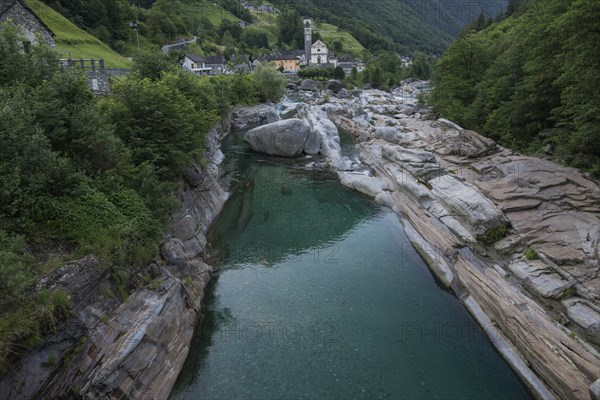 Bell tower by river in Ticino, Switzerland